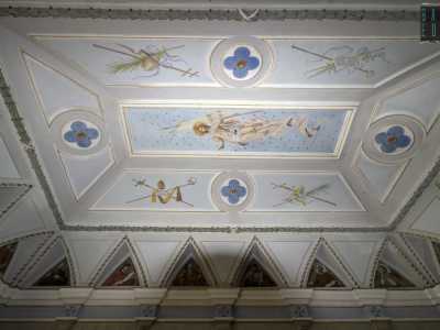 Al centro � raffigurato Ges� che regge uno stendardo circondato da decori blu a fiore e da simboli religiosi: bastoni pastorali, fronde di palme, mitre e crocifissi